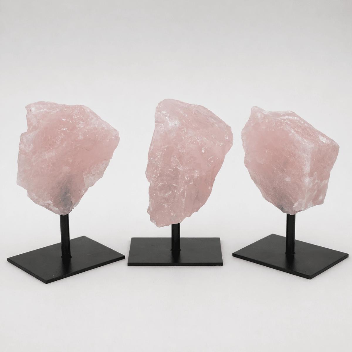 Rough rose quartz specimen on a metal stand