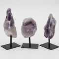 Rough amethyst specimen on a metal stand